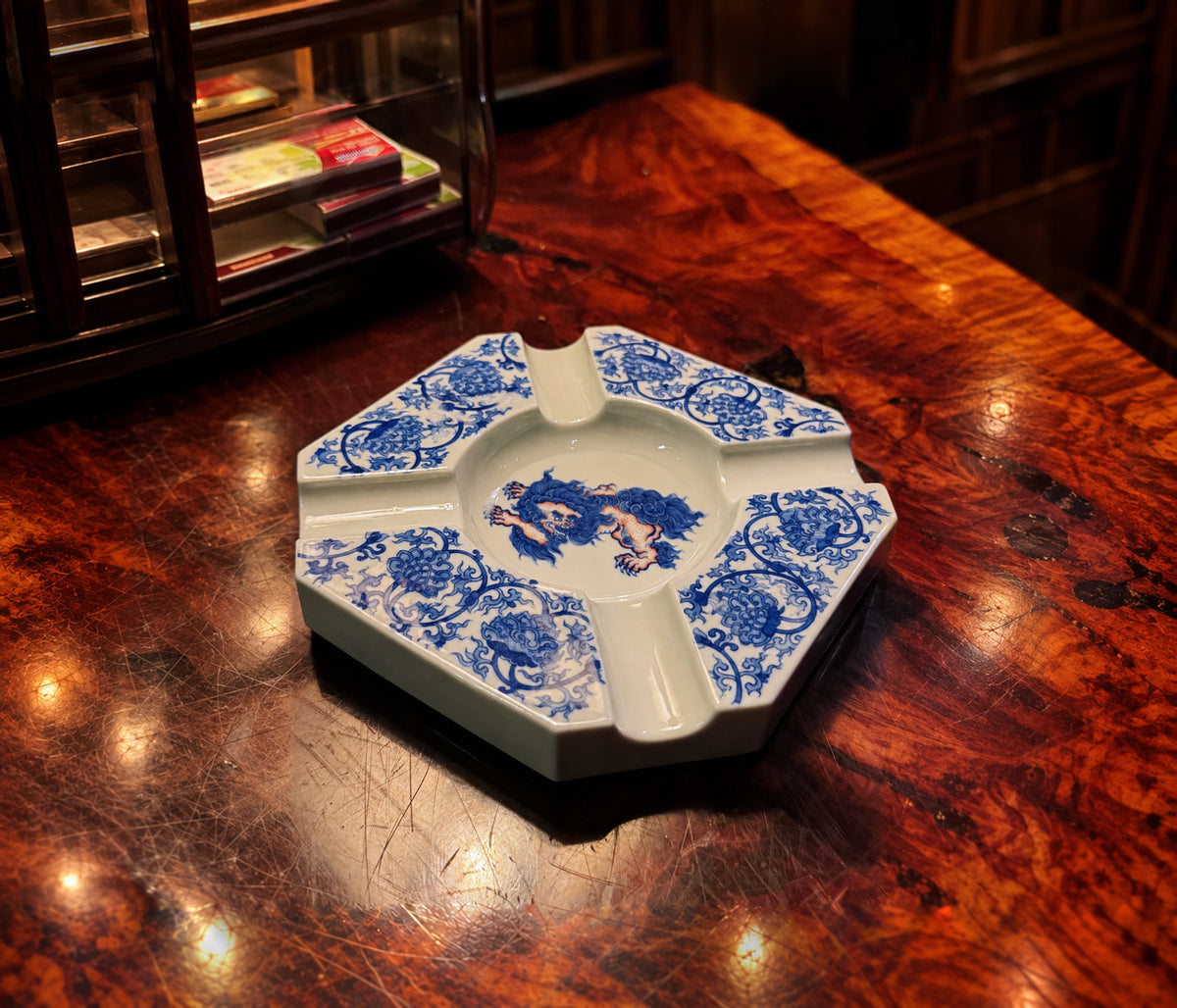 Blue-and-white porcelain ashtray on a polished wood table