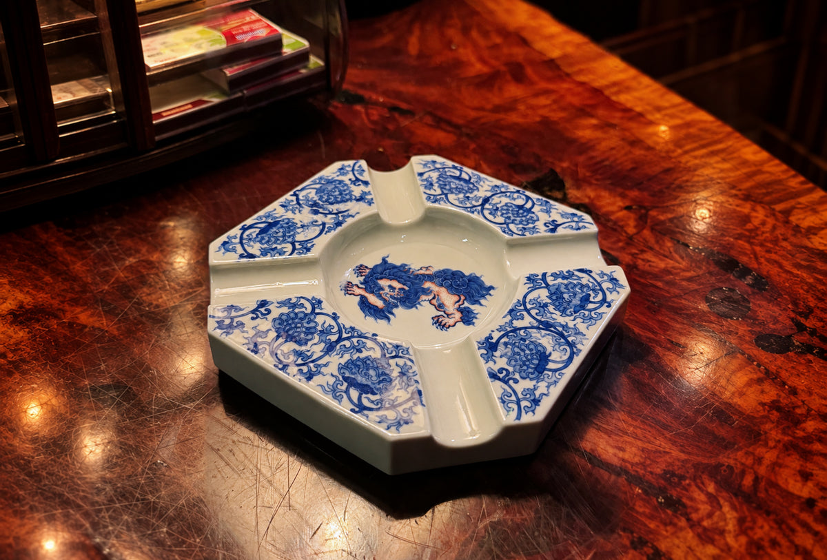 Blue-and-white porcelain ashtray on a polished wood table