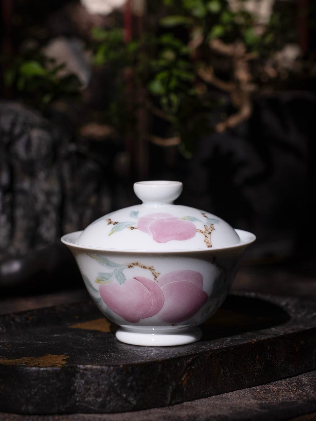 Hand holding a porcelain cup with floral decoration