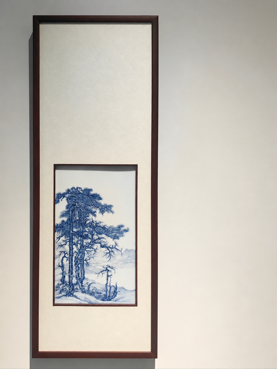 Blue landscape painted on porcelain in a tall dark frame